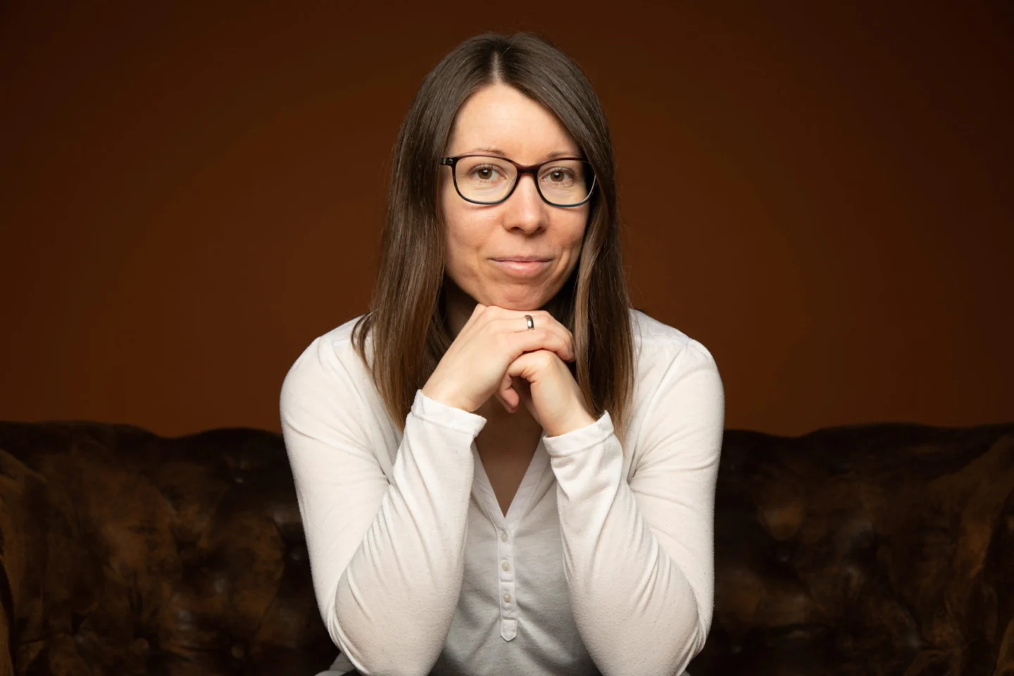 Steffi Markowic sitzt auf einem Sofa, die Hände unter dem Kinn.